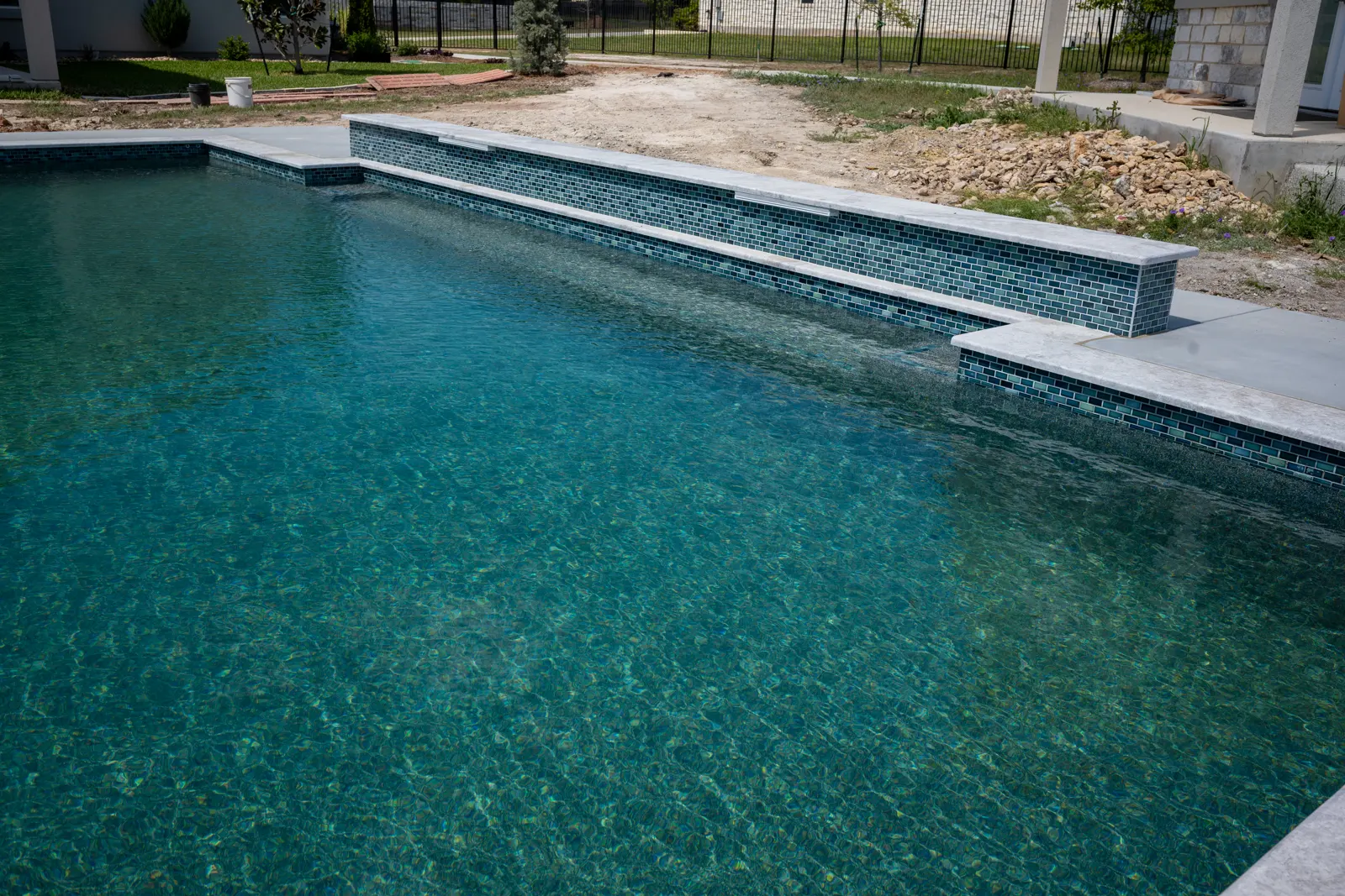 Shallow tanning ledge below a tiled spillway wall